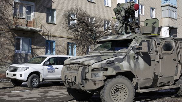 A Ukrainian serviceman stands on top of a KRAZ armoured vehicle close to a car of the Organization for Security and Cooperation in Europe (OSCE) in Soledar, Donetsk region. (File) - Sputnik International