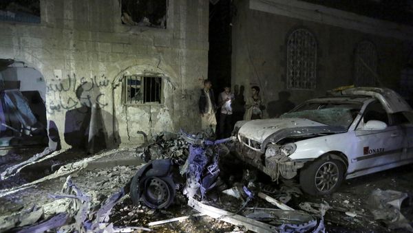 People stand next to wreckage at the site of a car bomb attack in Yemen's capital Sanaa June 29, 2015 - Sputnik International