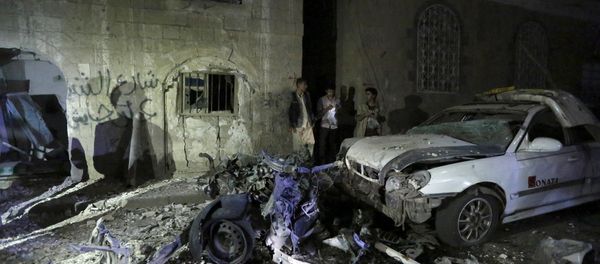 People stand next to wreckage at the site of a car bomb attack in Yemen's capital Sanaa June 29, 2015 - Sputnik International