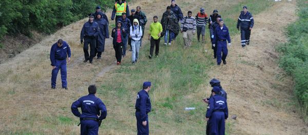 Police officers escort illegal migrants Police officers escort illegal migrants - Sputnik International