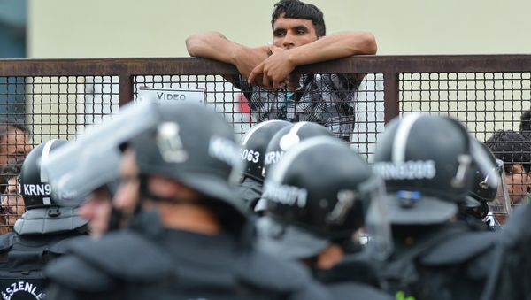 Policemen stand at the entrance of the Debrecen refugee camp in Debrecen, 230 kms from Budapest, Hungary, Monday, June 29, 2015. Police say they used tear gas to stop hundreds of refugees involved in a fight at a refugee camp in this eastern Hungarian city. - Sputnik International