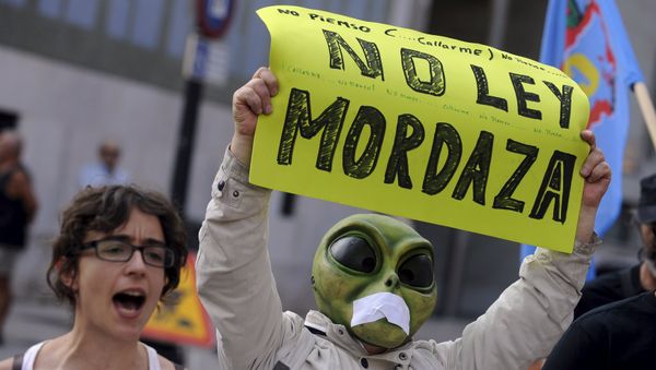 A man wearing a mask with a tape over the mouth holds up a sign during a protest against the Spanish government's new security law in Gijon, northern Spain, June 30, 2015 A man wearing a mask with a tape over the mouth holds up a sign during a protest against the Spanish government's new security law in Gijon, northern Spain, June 30, 2015 - Sputnik International