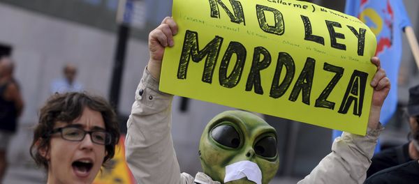 A man wearing a mask with a tape over the mouth holds up a sign during a protest against the Spanish government's new security law in Gijon, northern Spain, June 30, 2015 A man wearing a mask with a tape over the mouth holds up a sign during a protest against the Spanish government's new security law in Gijon, northern Spain, June 30, 2015 - Sputnik International