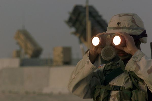 US soldier uses a pair of binoculars to scans the landscape around his Patriot Missiles based at Al Udeid AB, Qatar - Sputnik International