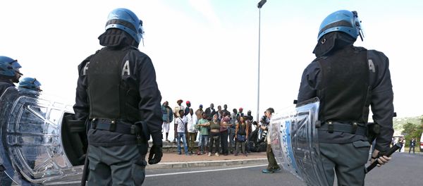 Italian policemen stand in front of migrants at the Franco-Italian border near Menton, southeastern France, Tuesday, June 16, 2015 Italian policemen stand in front of migrants at the Franco-Italian border near Menton, southeastern France, Tuesday, June 16, 2015 - Sputnik International