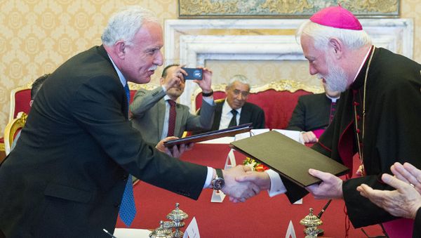 Vatican Foreign Minister Paul Gallagher, right, and his Palestinian counterpart, Riad al-Malki, shake hands after signing a treaty at a ceremony inside the Vatican, Friday, June 26, 2015 Vatican Foreign Minister Paul Gallagher, right, and his Palestinian counterpart, Riad al-Malki, shake hands after signing a treaty at a ceremony inside the Vatican, Friday, June 26, 2015 - Sputnik International