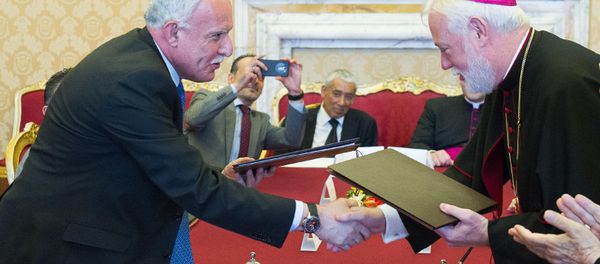 Vatican Foreign Minister Paul Gallagher, right, and his Palestinian counterpart, Riad al-Malki, shake hands after signing a treaty at a ceremony inside the Vatican, Friday, June 26, 2015 - Sputnik International