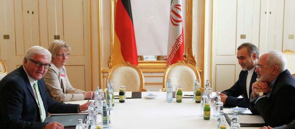 German Foreign Minister Frank-Walter Steinmeier (L) and Iranian Foreign Minister Javad Zarif wait for the start of a bilateral meeting in Palais Coburg, the venue for nuclear talks in Vienna, Austria, July 2, 2015 - Sputnik International