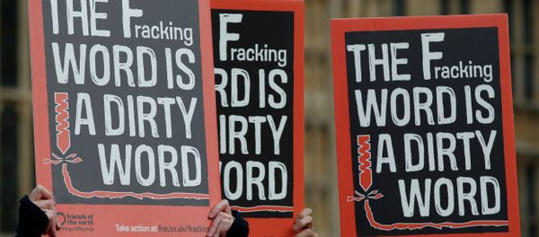 Demonstrators hold up placards as they take part in an anti-fracking protest outside the Palace of Westminster in London. - Sputnik International