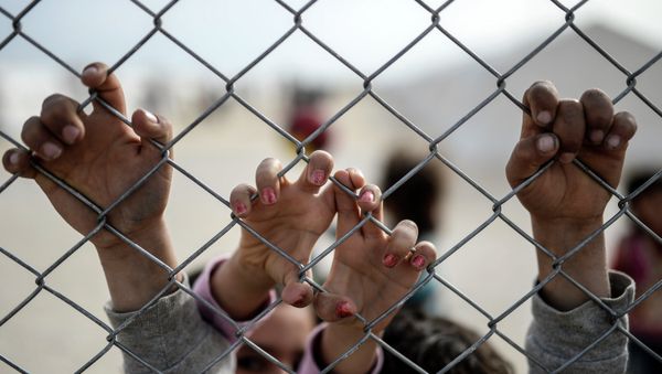 Hands of Syrian Kurdish children are seen holding a fence in a UNHCR (United Nations Refugee Agency) refugee camp on February 2, 2015, at Suruc, in Sanliurfa - Sputnik International