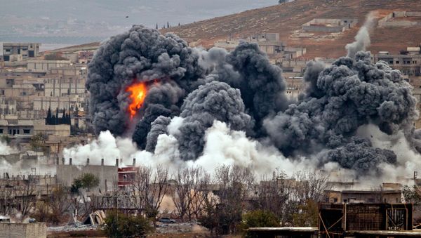 Smoke rises from the Syrian city of Kobani, following an airstrike by the US led coalition, seen from a hilltop outside Suruc, on the Turkey-Syria border Monday, Nov. 17, 2014. - Sputnik International