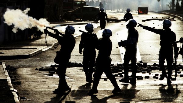 Riot police fire tear gas toward anti-government protesters, unseen, in Jidhafs, Bahrain, on Friday, March 15, 2013 - Sputnik International
