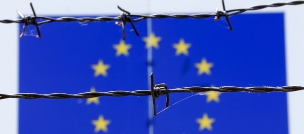 A barbed wire is seen in front of a European Union flag A barbed wire is seen in front of a European Union flag - Sputnik International