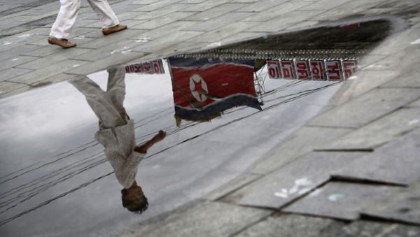 A North Korean woman is reflected in a rain puddle as she walks past the country's national flag along the Kim Il Sung Square on Sunday, July 21, 2013, downtown Pyongyang, North Korea A North Korean woman is reflected in a rain puddle as she walks past the country's national flag along the Kim Il Sung Square on Sunday, July 21, 2013, downtown Pyongyang, North Korea - Sputnik International