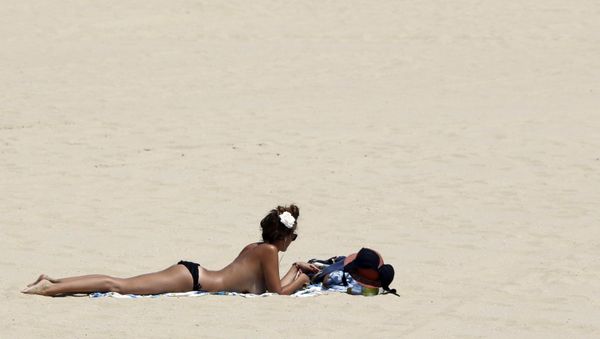 A woman sunbathes on a beach along the Bassin d'Arcachon Sea during a warm and sunny day in Arcachon near Bordeaux, southwestern France, July 1, 2015. A woman sunbathes on a beach along the Bassin d'Arcachon Sea during a warm and sunny day in Arcachon near Bordeaux, southwestern France, July 1, 2015. - Sputnik International