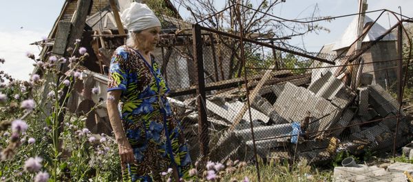 A woman walks past her damaged house, which according to locals was hit by shelling on Wednesday, the village of Sakhanka in Donetsk region, Ukraine, July 2, 2015 A woman walks past her damaged house, which according to locals was hit by shelling on Wednesday, the village of Sakhanka in Donetsk region, Ukraine, July 2, 2015 - Sputnik International