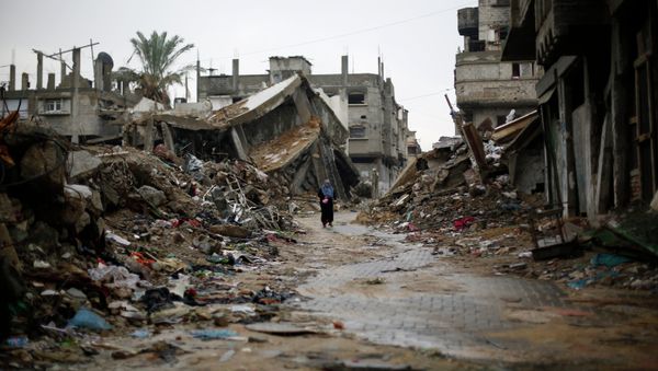 A Palestinian woman walks in the rain past houses that were destroyed during the 50-day Gaza war between Israel and Hamas-led militants, on November 24, 2014, in Gaza City A Palestinian woman walks in the rain past houses that were destroyed during the 50-day Gaza war between Israel and Hamas-led militants, on November 24, 2014, in Gaza City - Sputnik International