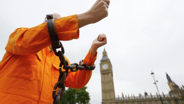 A protester holds up his chained arms during a protest against the Guantanamo Bay detention camp, in Parliament Square in London, Wednesday, Oct. 15, 2014 A protester holds up his chained arms during a protest against the Guantanamo Bay detention camp, in Parliament Square in London, Wednesday, Oct. 15, 2014 - Sputnik International