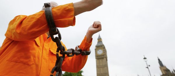 A protester holds up his chained arms during a protest against the Guantanamo Bay detention camp, in Parliament Square in London, Wednesday, Oct. 15, 2014 A protester holds up his chained arms during a protest against the Guantanamo Bay detention camp, in Parliament Square in London, Wednesday, Oct. 15, 2014 - Sputnik International