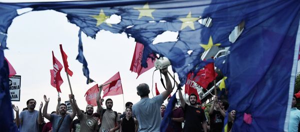 Members of left wing parties shout slogans behind a burning European Union flag during an anti-EU protest in the northern Greek port city of Thessaloniki, Sunday, June 28, 2015 Members of left wing parties shout slogans behind a burning European Union flag during an anti-EU protest in the northern Greek port city of Thessaloniki, Sunday, June 28, 2015 - Sputnik International