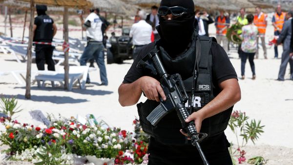 A hooded Tunisian police officer stands guard ahead of the visit of top security officials of Britain, France, Germany and Belgium at the scene of Friday's shooting attack in front of the Imperial Marhaba hotel in the Mediterranean resort of Sousse, Tunisa, Monday, June 29, 2015 - Sputnik International