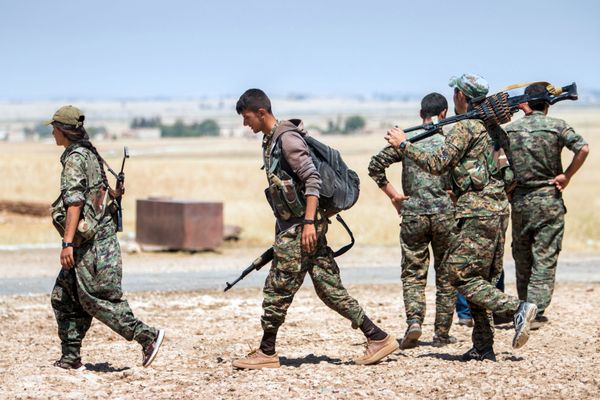 Kurdish People's Protection Units (YPG) fighters walk with their weapons at the eastern entrances to the town of Tal Abyad in the northern Raqqa countryside, Syria, June 14, 2015 - Sputnik International