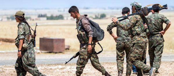 Kurdish People's Protection Units (YPG) fighters walk with their weapons at the eastern entrances to the town of Tal Abyad in the northern Raqqa countryside, Syria, June 14, 2015 - Sputnik International