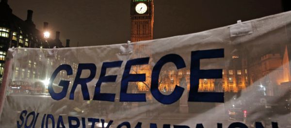 Backdropped by the Houses of Parliament in central London, protesters hold a banner at a rally to show solidarity with Greece. File photo - Sputnik International