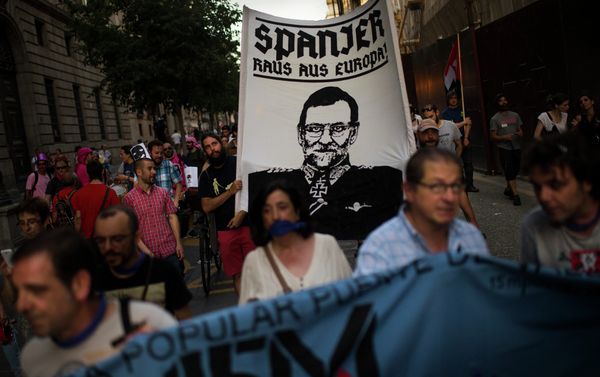 Protestors march as they carry a flag with a caricature representing Span's Prime Minister Mariano Rajoy dressed in a nazi uniform reading Spanish, out of Europe as they protest against the Public Security Law in Madrid, Spain Protestors march as they carry a flag with a caricature representing Span's Prime Minister Mariano Rajoy dressed in a nazi uniform reading Spanish, out of Europe as they protest against the Public Security Law in Madrid, Spain - Sputnik International