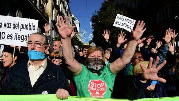 Demonstrators hold placards reading A country with a gag doesn't move as they protest against the new public security law (ley mordaza) approved by the lower house of parliament, in Madrid on December 20, 2014 - Sputnik International