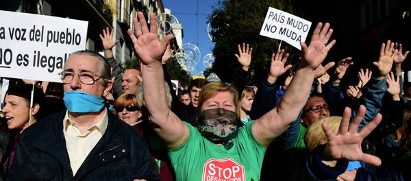 Demonstrators hold placards reading A country with a gag doesn't move as they protest against the new public security law (ley mordaza) approved by the lower house of parliament, in Madrid on December 20, 2014 Demonstrators hold placards reading A country with a gag doesn't move as they protest against the new public security law (ley mordaza) approved by the lower house of parliament, in Madrid on December 20, 2014 - Sputnik International