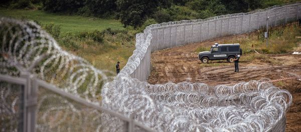 Border policemen stand guard next to a barbed wire wall on the Bulgarian border with Turkey, near the village of Golyam Dervent Border policemen stand guard next to a barbed wire wall on the Bulgarian border with Turkey, near the village of Golyam Dervent - Sputnik International