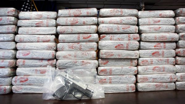 A firearm and 154 pounds of heroin worth at least $50 million are displayed at a Drug Enforcement Administration news conference. - Sputnik International