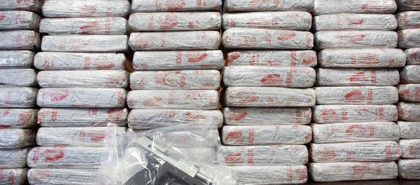 A firearm and 154 pounds of heroin worth at least $50 million are displayed at a Drug Enforcement Administration news conference. - Sputnik International