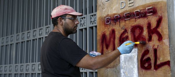 A worker cleans graffiti outside the central Bank of Greece building in Athens, Greece, July 7, 2015 A worker cleans graffiti outside the central Bank of Greece building in Athens, Greece, July 7, 2015 - Sputnik International