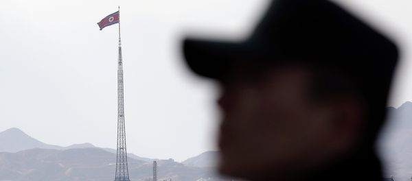 A South Korean soldier stands as a North Korean flag flutters in the wind atop a 160-meter (533-foot) tower in the village of Gijungdong near the north side of the border village of Panmunjom, which has separated the two Koreas since the Korean War, in Paju, north of Seoul, South Korea, Wednesday, Nov. 12, 2014 A South Korean soldier stands as a North Korean flag flutters in the wind atop a 160-meter (533-foot) tower in the village of Gijungdong near the north side of the border village of Panmunjom, which has separated the two Koreas since the Korean War, in Paju, north of Seoul, South Korea, Wednesday, Nov. 12, 2014 - Sputnik International
