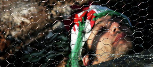 An Israeli activist lays behind wire fencing as he and others try to stop Israeli bulldozers, not seen, from working, during a joint protest with Israelis, Palestinians and foreign peace activists against Israel's seperation barrier in the West Bank. An Israeli activist lays behind wire fencing as he and others try to stop Israeli bulldozers, not seen, from working, during a joint protest with Israelis, Palestinians and foreign peace activists against Israel's seperation barrier in the West Bank. - Sputnik International