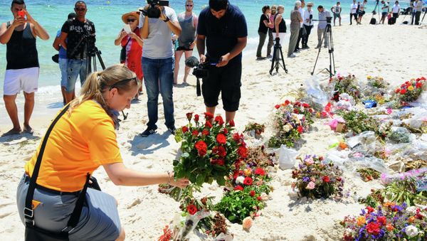 An unidentified tourist lays flowers to honor the victims of the June 26 terrorist attack in Tunisia. - Sputnik International