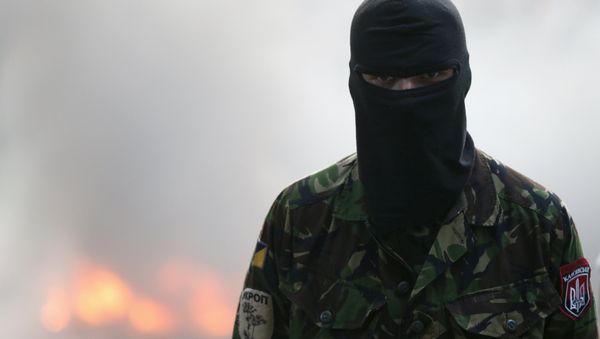 A participant looks on during a rally held by members of the far-right radical group Right Sector, representatives of the Ukrainian volunteer corps and their supporters, with tyres set on fire seen in the background, in central Kiev, Ukraine, July 3, 2015 - Sputnik International