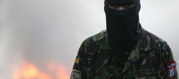 A participant looks on during a rally held by members of the far-right radical group Right Sector, representatives of the Ukrainian volunteer corps and their supporters, with tyres set on fire seen in the background, in central Kiev, Ukraine, July 3, 2015 A participant looks on during a rally held by members of the far-right radical group Right Sector, representatives of the Ukrainian volunteer corps and their supporters, with tyres set on fire seen in the background, in central Kiev, Ukraine, July 3, 2015 - Sputnik International
