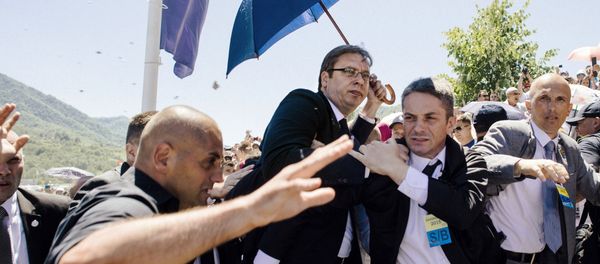 Bodyguards try to protect Serbian Prime Minister Aleksandar Vucic (C) from stones hurled at him by an angry crowd at the Potocari Memorial Center, near the eastern Bosnian town of Srebrenica on July 11, 2015 Bodyguards try to protect Serbian Prime Minister Aleksandar Vucic (C) from stones hurled at him by an angry crowd at the Potocari Memorial Center, near the eastern Bosnian town of Srebrenica on July 11, 2015 - Sputnik International