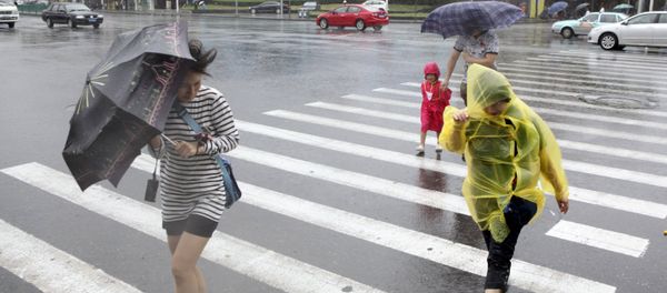 Pedestrians hold their umbrellas against strong wind China Pedestrians hold their umbrellas against strong wind China - Sputnik International