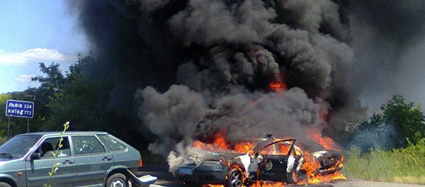 Two police cars on fire are seen at the site of unrest in Mukhachevo, Western Ukraine, Saturday, July 11, 2015 - Sputnik International