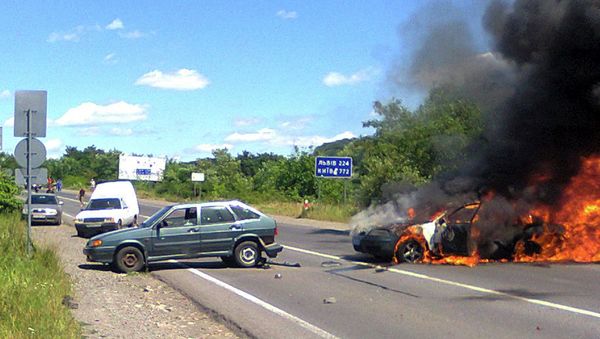 A police car is seen on fire at the site of unrest in Mukachevo, Western Ukraine, Saturday, July 11, 2015 A police car is seen on fire at the site of unrest in Mukachevo, Western Ukraine, Saturday, July 11, 2015 - Sputnik International