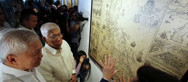 Philippine Foreign Affairs Secretary Albert del Rosario, left, and Defense Secretary Voltaire Gazmin, center, listen during a cartographic exhibit entitled “Historical Truths and Lies: Scarborough Shoal in Ancient Maps.” - Sputnik International