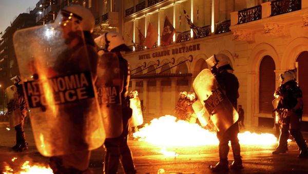 Riot police stand amongst the flames from exploded petrol bombs thrown by a small group of anti-austerity demonstrators in front of parliament in Athens, Greece July 15, 2015 Riot police stand amongst the flames from exploded petrol bombs thrown by a small group of anti-austerity demonstrators in front of parliament in Athens, Greece July 15, 2015 - Sputnik International