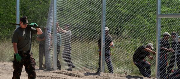 Local soldiers of the Hungarian Army's technical unit set the first elements of the 150 meters long metal fence at the Hungarian-Serbian border nearby Morahalom village on July 16, 2015 Local soldiers of the Hungarian Army's technical unit set the first elements of the 150 meters long metal fence at the Hungarian-Serbian border nearby Morahalom village on July 16, 2015 - Sputnik International