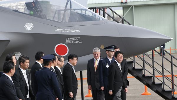 Japan's Prime Minister Shinzo Abe, right, looks at a mock-up of F-35 fighter jet. - Sputnik International