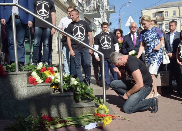 A man kneels down in front of flowers laid in front of the Dutch embassy in Kiev on July 17, 2015 in memory of the people who died in the crash of Malaysian Airlines flight MH17 A man kneels down in front of flowers laid in front of the Dutch embassy in Kiev on July 17, 2015 in memory of the people who died in the crash of Malaysian Airlines flight MH17 - Sputnik International