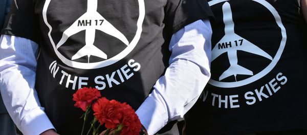 People wearing t-shirts bearing a drawing of a plane and slogans reading MH 17, One year in the skies hold flowers to the Dutch embassy in Kiev on July 17, 2015 People wearing t-shirts bearing a drawing of a plane and slogans reading MH 17, One year in the skies hold flowers to the Dutch embassy in Kiev on July 17, 2015 - Sputnik International